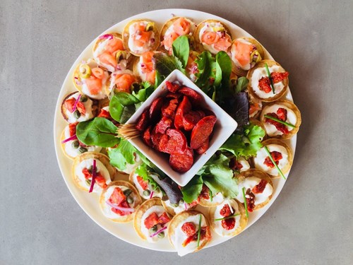 Aerial view of a round plate covered with a variety of canapes